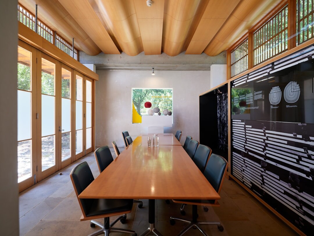 Modern boardroom with a wooden meeting table and large windows